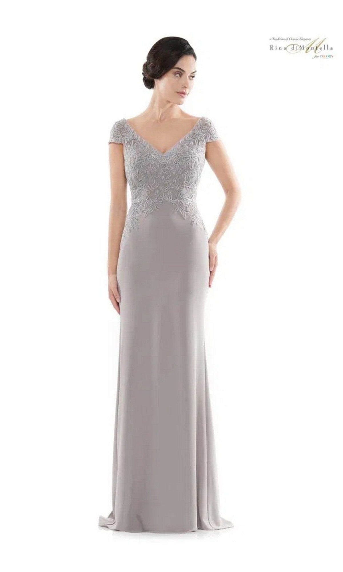 A woman in the Rina Di Montella RD2718 long formal dress, light mauve color, with short sleeves and an embroidered bodice, stands against a plain white background.